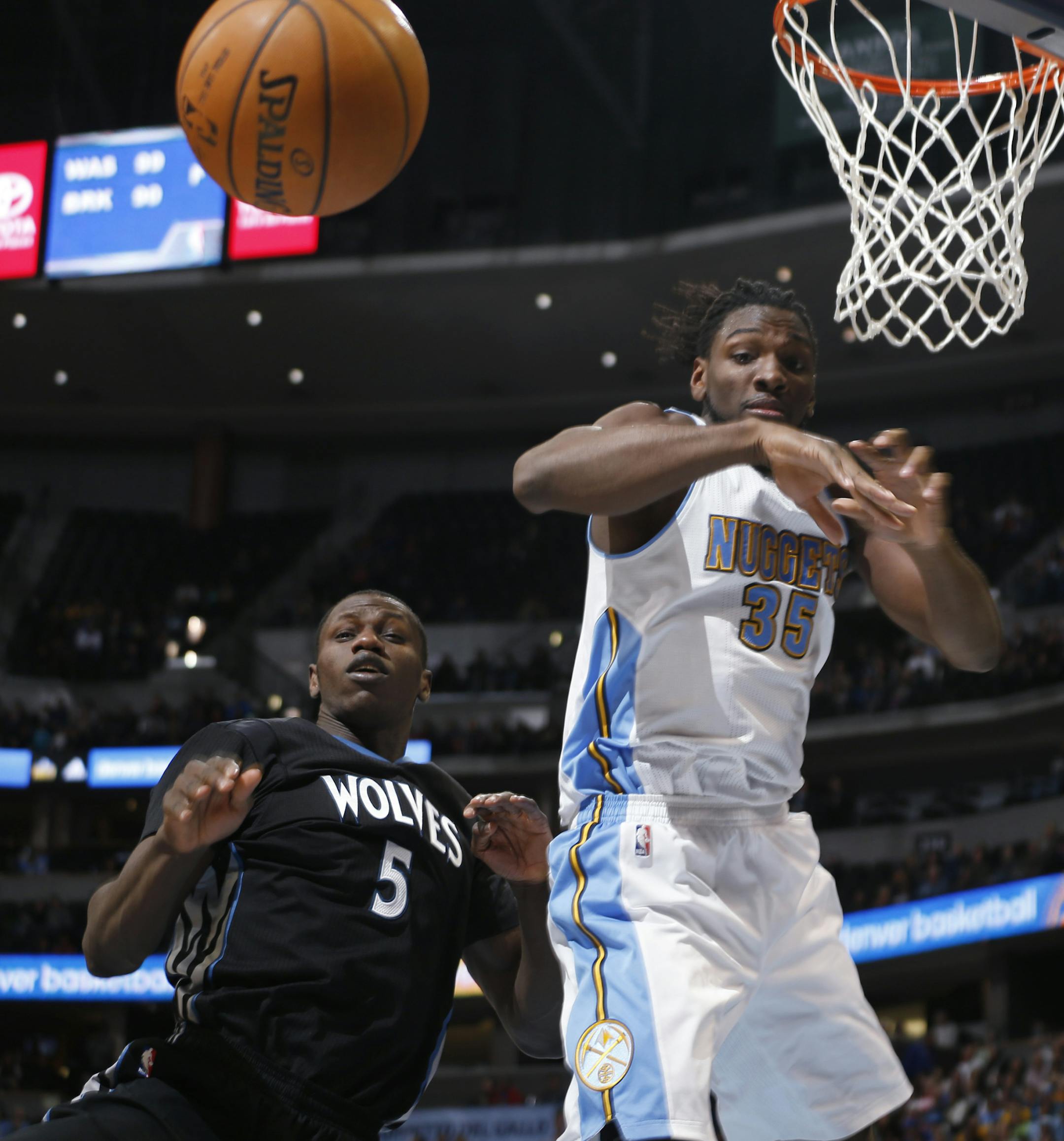Minnesota Timberwolves center Gorgui Dieng, left, of Senegal, and Denver Nuggets forward Kenneth Faried watch as the ball bounces out of play in the fourth quarter of an NBA basketball game Saturday, Jan. 17, 2015, in Denver. (AP Photo/David Zalubowski)