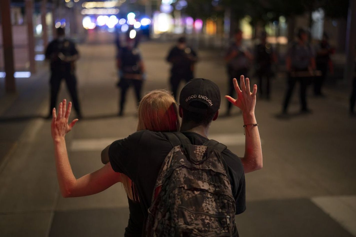 On Wednesday night in Minneapolis, a couple stood opposite a line of police securing Nicollet Mall after an officer was hit by a flying object.