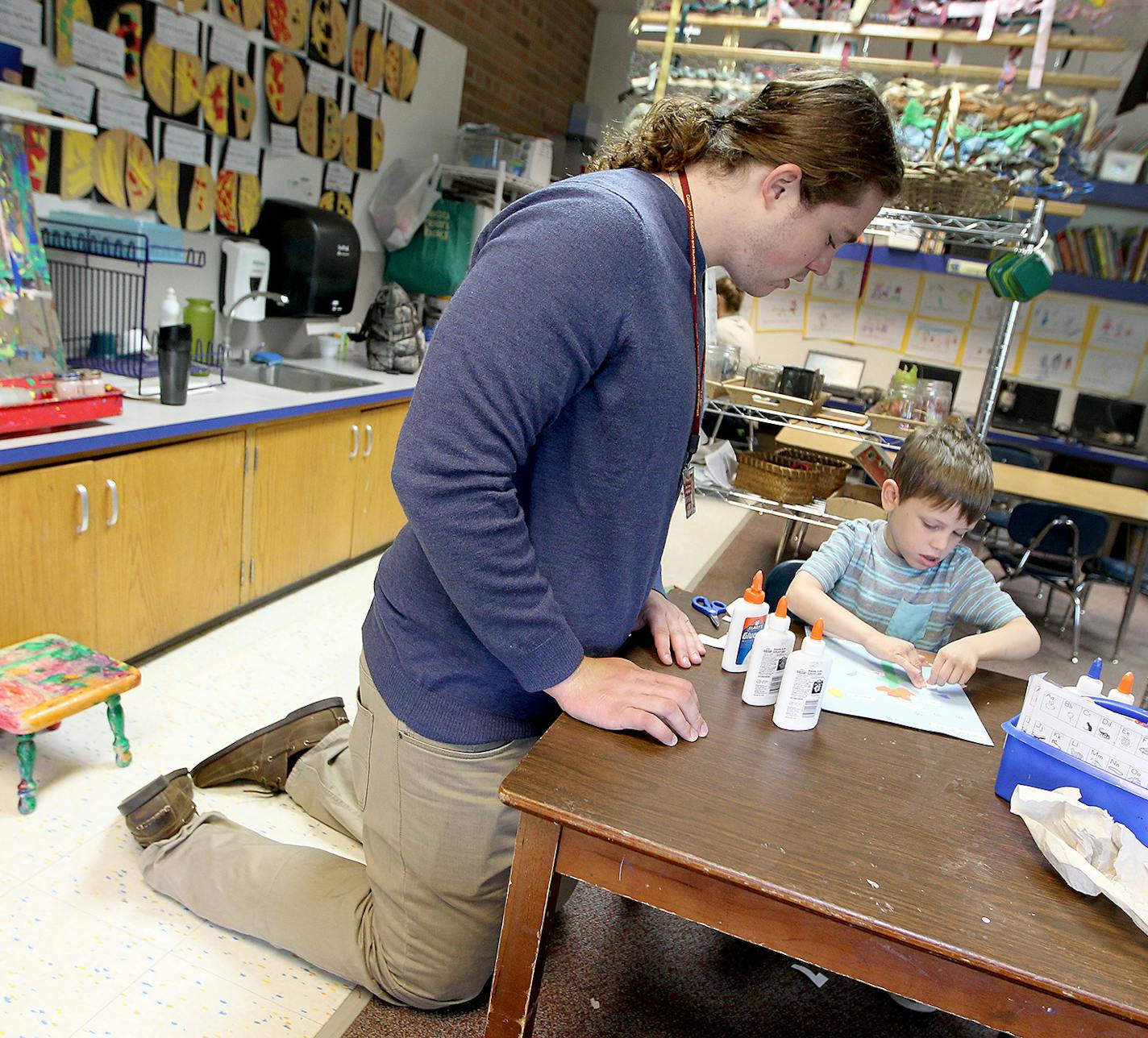 Gophers offensive tackle Jonah Pirsig helped David Schwantes, 5, with his class science project at Highlands Elementary, Tuesday, May 5, 2015 in Edina.