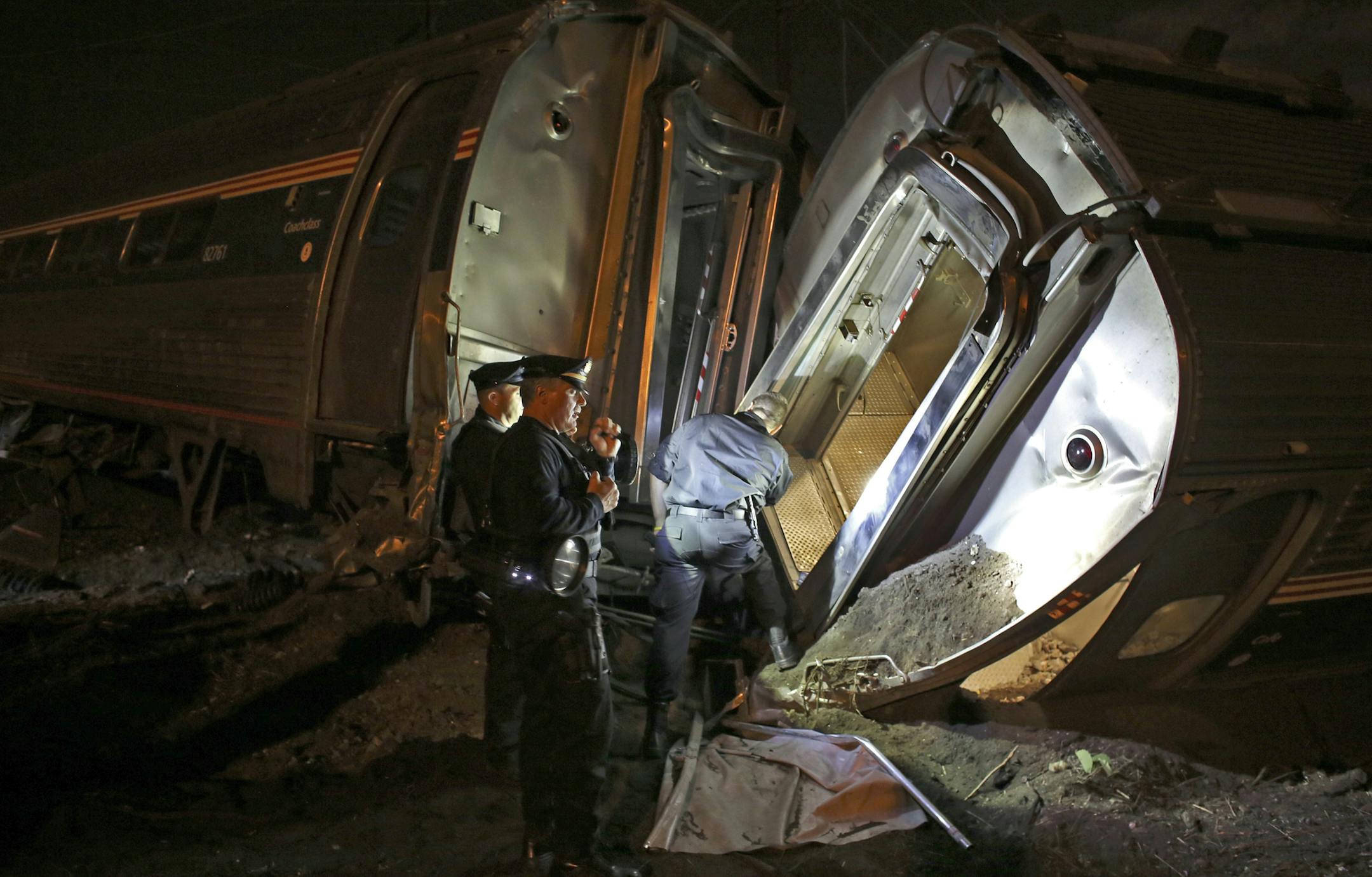 FILE - In this May 12, 2015 file photo, emergency personnel work the scene of a train wreck An Amtrak train headed to New York City derailed and crashed in Philadelphia. Amtrak says it will install video cameras inside locomotive cabs that record the actions of train engineers. The move follows a deadly derailment earlier this month in which investigators are searching for clues to the train engineer's actions just before the crash. (AP Photo/Joseph Kaczmarek, File)