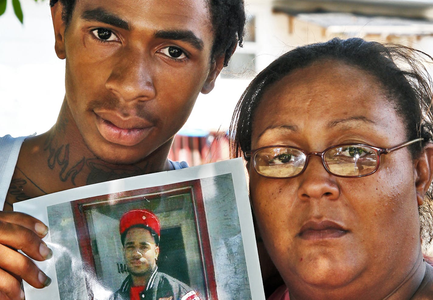 Family of Mark Eric Henderson Jr., 19, of St. Paul, who was fatally shot by police in an incident in Woodbury yesterday. Left, brother Fred Henderson, 18, and mother Tawana Henderson, both of St. Paul, held a photo of Mark Henderson Jr. (MARLIN LEVISON/STARTRIBUNE(mlevison@startribune.com (cq reporter and Fred Henderson) ORG XMIT: MIN1209011517305581