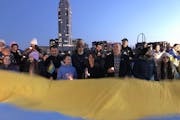 U.S. Sen. Amy Klobuchar helped hold a large Ukrainian flag on the Stone Arch Bridge at a rally to support that country on the second anniversary of Ru