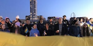 U.S. Sen. Amy Klobuchar helped hold a large Ukrainian flag on the Stone Arch Bridge at a rally to support that country on the second anniversary of Ru