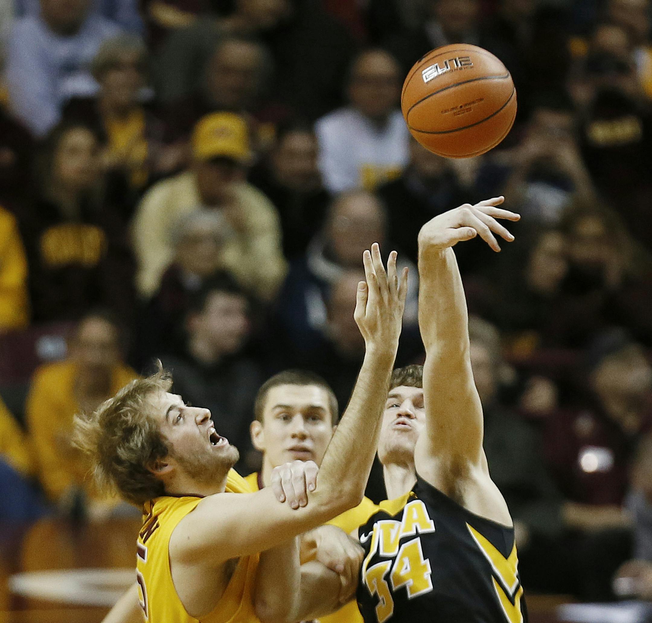 Iowa Hawkeyes center Adam Woodbury (34) tipped the ball away from Minnesota Gophers center Elliott Eliason (55) at tip off Tuesday at Williams arena January 13, 2015 Minneapolis, MN.] Minnesota hosted Iowa in Big Ten action Tuesday night at Williams Arena.] Jerry Holt/ Jerry.Holt@Startribune.com
