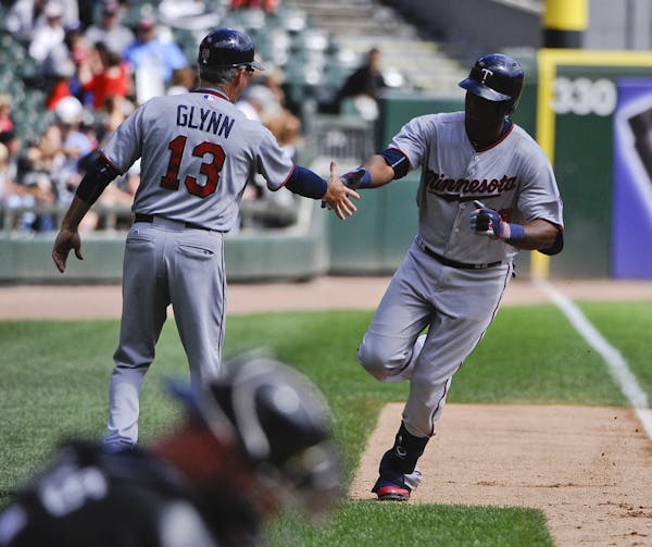 Minnesota Twins' Torii Hunter, right, high-fives third base coach Gene Glynn (13) after hitting a three-run home run in the first inning of a baseball