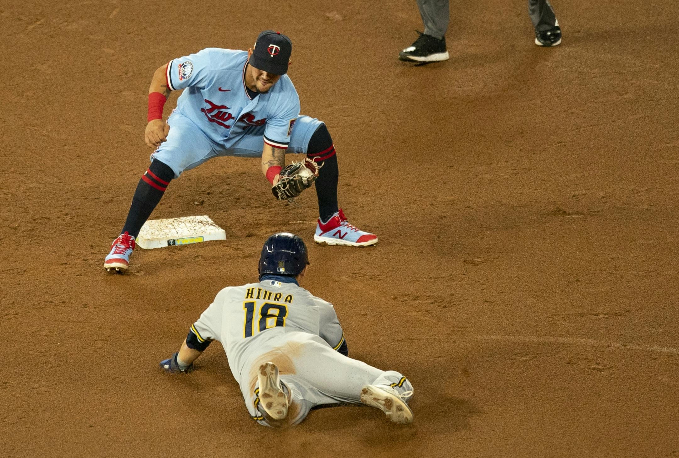 Minnesota Twins second baseman Ildemaro Vargas (4) prepared to tag out Milwaukee Brewers designated hitter Keston Hiura (18) as he tried to slide into second base.