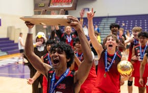 Eden Prairie’s Avi Kommalapati hoists the championship trophy aloft to show the Eagles student section after defeating Rogers for the first MSHSL-sa
