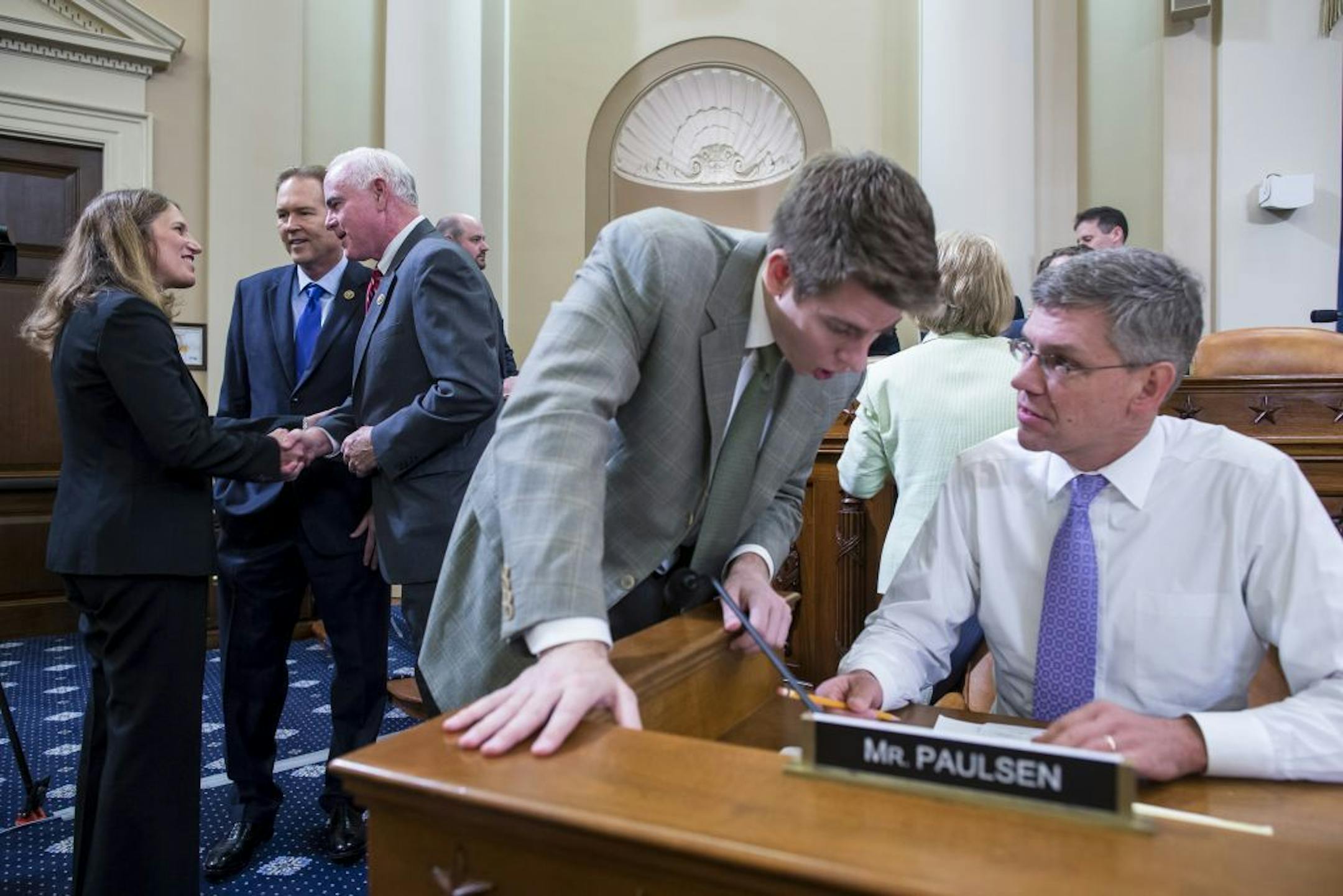 Rep. Erik Paulsen (R-Minn.) prepares for a House Ways and Means Committee hearing as Health and Human Services Secretary Sylvia Burwell, left, shakes hands with Rep. Pat Meehan (R-Pa.), on Capitol Hill in Washington, June 10, 2015. The hearing focused on the implementation of the Affordable Care Act.
