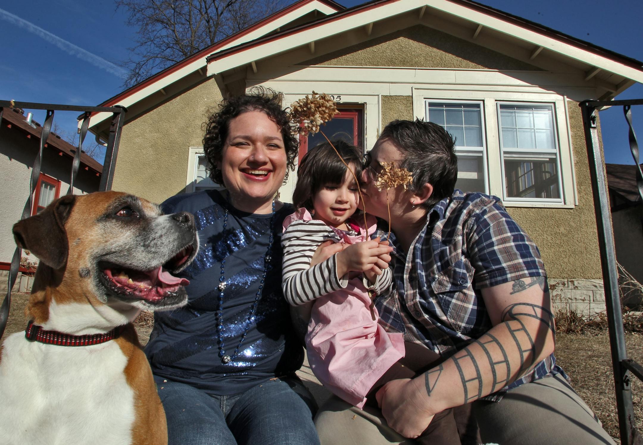 Rebecca Johnson and Carrie Agnew were saved from foreclosure of their Minneapolis home through proceedings on the Ellen Degeneres television show. Dog Brooklyn, Rebecca Johnson, daughter Ruby Agnew, 4 and Ruby Agnew sat in front of their Minneapolis home.