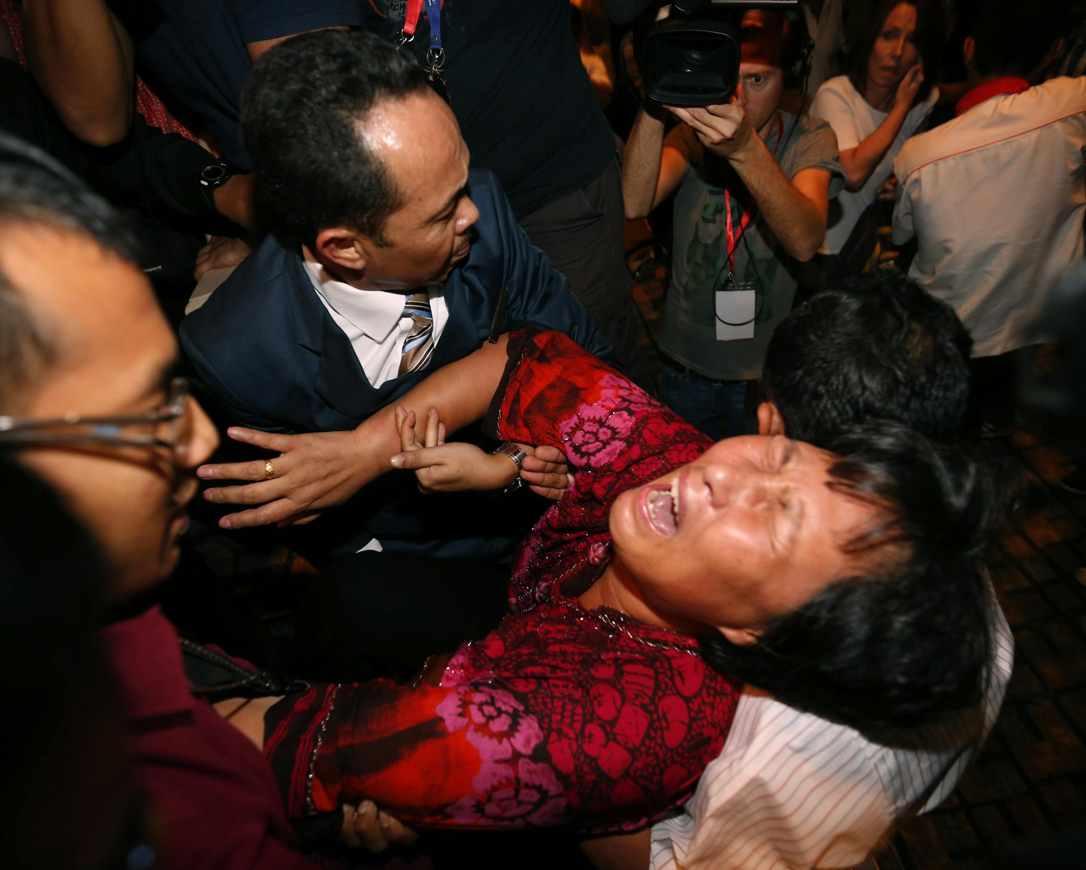 A Chinese relative of a passenger aboard a missing Malaysia Airlines plane is carried out by security officials as she protests before a press conference at a hotel in Sepang, Malaysia, Wednesday, March 19, 2014. New radar data from Thailand gave Malaysian investigators more potential clues Wednesday for how to retrace the course of the missing Malaysian airliner, while a massive multinational search unfolded in an area the size of Australia. (AP Photo/Vincent Thian)