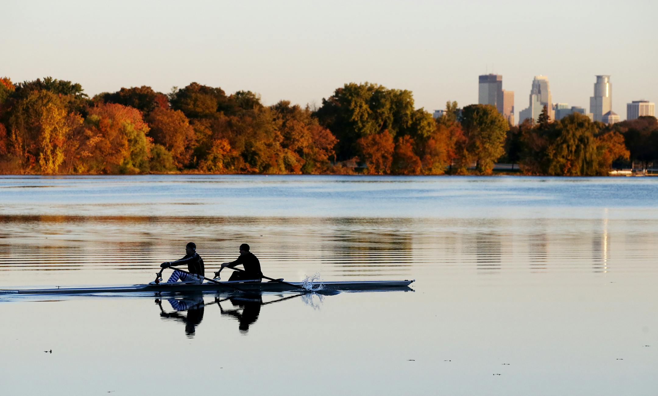 A rowing crew skims across a placid Lake Nokomis with fall colors and the Minneapolis skyline Thursday, Oct. 189, 2018, in Minneapolis, MN.] DAVID JOLES ï david.joles@startribune.com Standalone feature photo