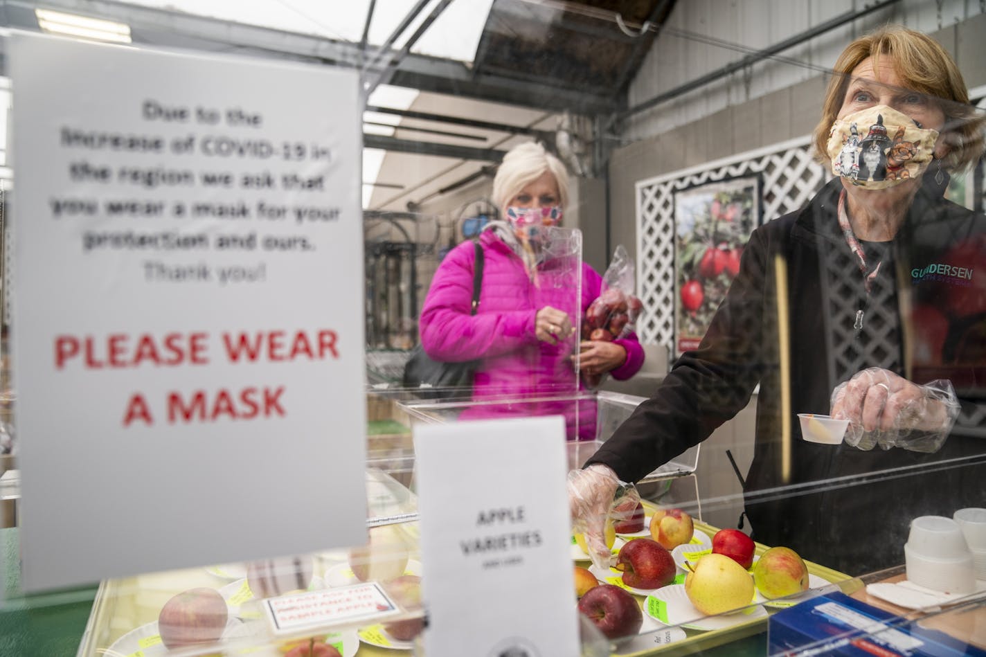 Jeanne Tippery, right, a retired nurse from Houston who works part-time at Bauer's Market in La Crescent, served apple samples to customer Pam Black of La Crescent, a fellow retired nurse. "Now I know people who have COVID," said Tippery, who said that was not the case a few months ago. "People need to take it seriously or it's never going to go away," said Black.