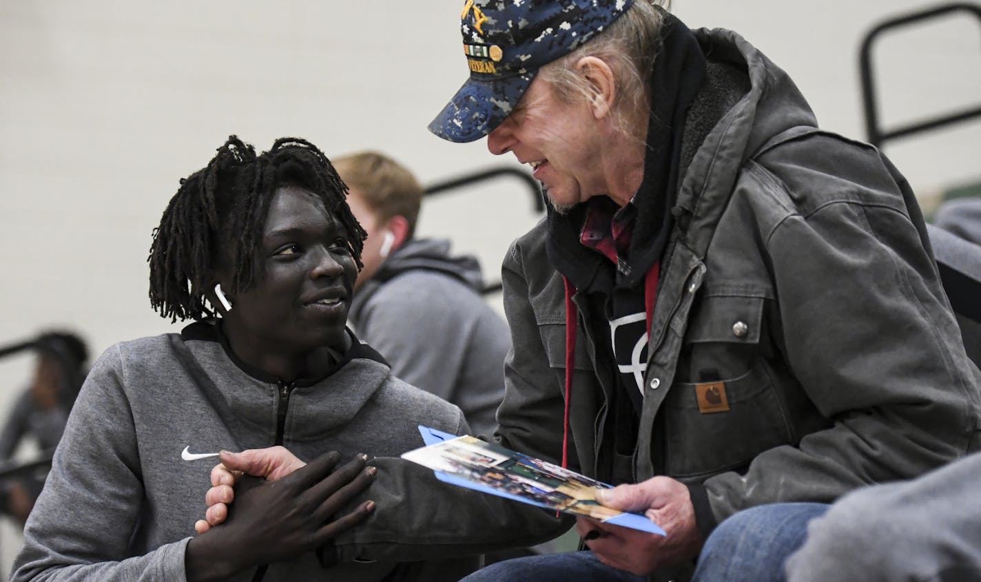 Agwa Nywesh shook hands with Dale Francis, an Austin fan who traveled to Faribault to watch Friday night's game. Francis had photos of the team and was going between players to get autographs. ] Aaron Lavinsky &#x2022; aaron.lavinsky@startribune.com Photos to accompany a feature on the ethnic diversification of Austin Minn., as seen through the Austin High School boys basketball and soccer programs, photographed Friday, Dec. 20, 2019.