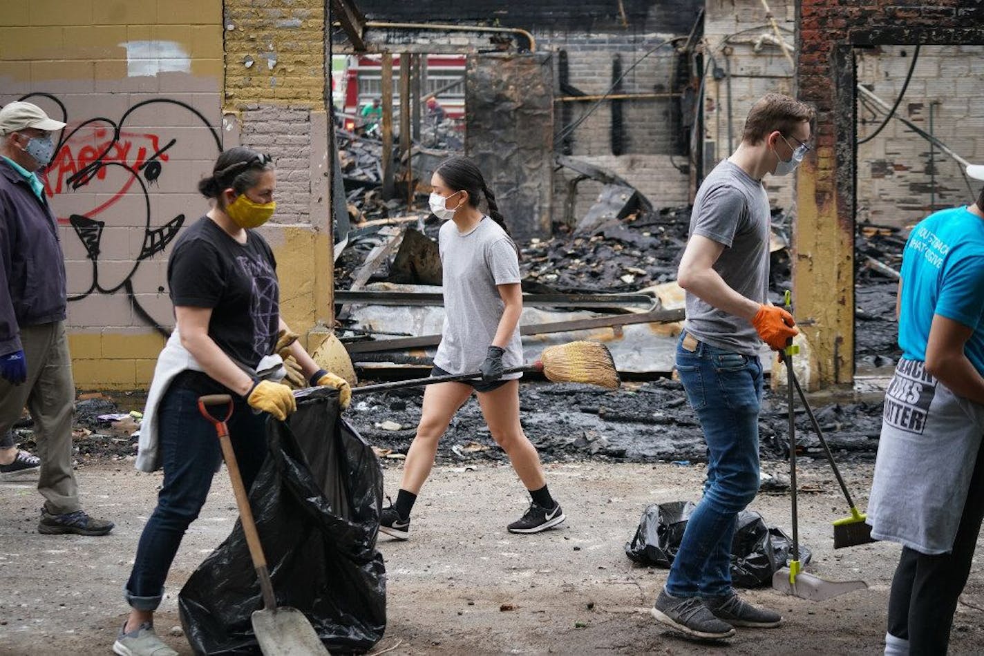 Volunteers cleaned up charred debris in the alleyway behind the vandalized Sports Dome on University Avenue in St. Paul on Friday, May 29, 2020. Shari L. Gross • shari.gross@startribune.com