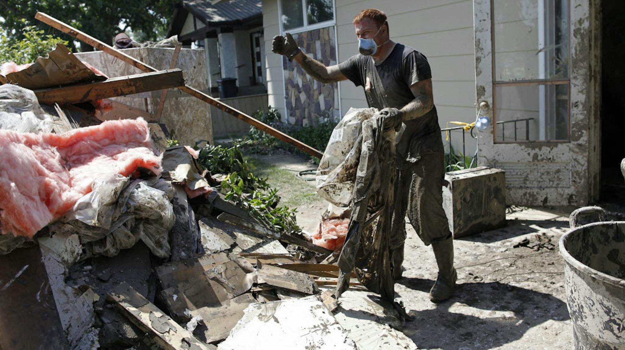 Yahya Abougoush helps clean up his parents' house in High River, Alberta, Canada, after torrential rain filled up creeks and rivers and surged over their banks causing floods throughout much of southern Alberta.