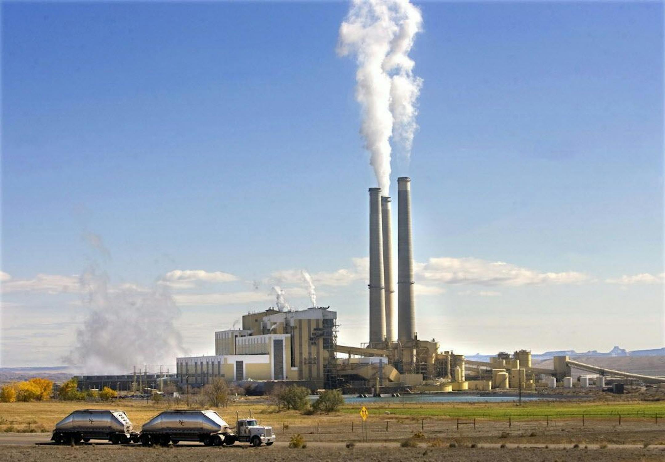 FILE - In this file photo, coal trucks leave the coal-fired Hunter Power Plant just south of Castle Dale, Utah, after making a delivery.