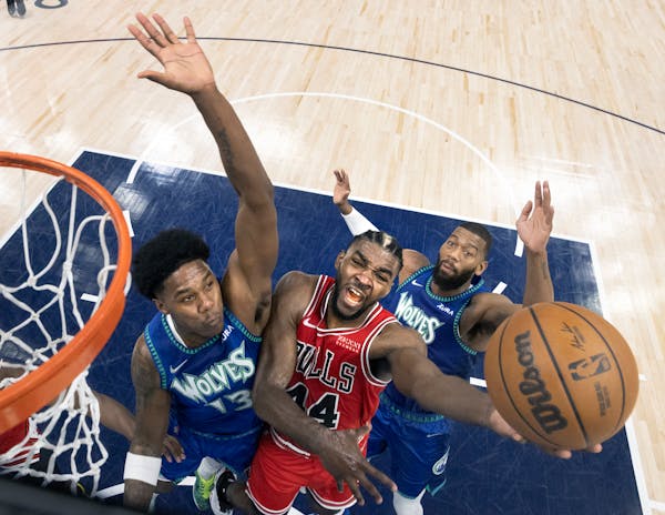 Patrick Williams (44) of the Chicago Bulls attempts a shot while defended by Nathan Knight (13) and Greg Monroe (55) of the Minnesota Timberwolves.