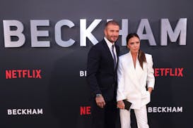 David Beckham, left, and Victoria Beckham pose for photographers upon arrival at the premiere of the television program “Beckham” on Tuesday, Oct.