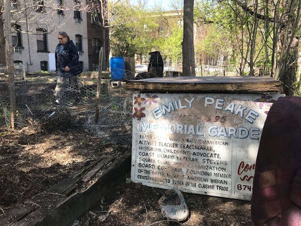 Cheryl Magnell, steward of the Emily Peake Memorial Garden, walks past a faded sign for the garden on Tuesday, May 7, 2019. The owner of the property 