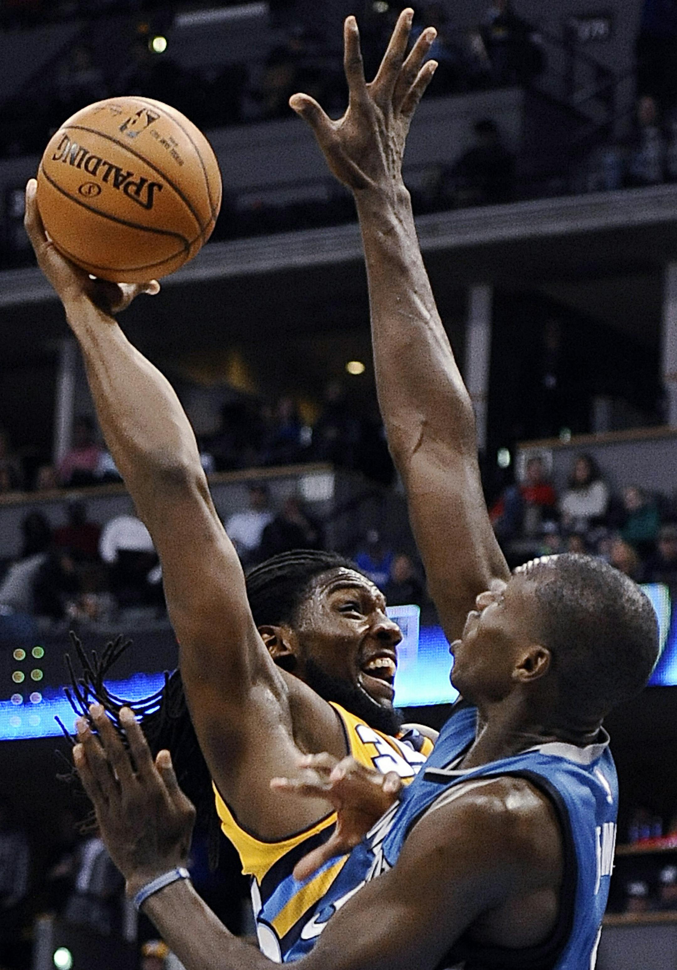 Denver Nuggets forward Kenneth Faried, left, tries to dunk over Minnesota Timberwolves center Gorgui Dieng during the second half of an NBA basketball game Friday, Dec. 26, 2014 in Denver. Denver won 106-102. (AP Photo/Chris Schneider)