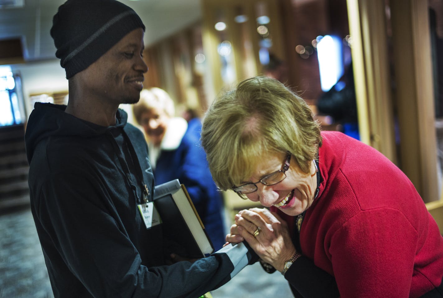 Kaludji Ruteye, a native of the Congo who resettled in Minnesota in August, attends services at New Life Presbyterian. Members of the congregation, including orchestra member Barb Nelson (shown), have rallied around Ruteye.