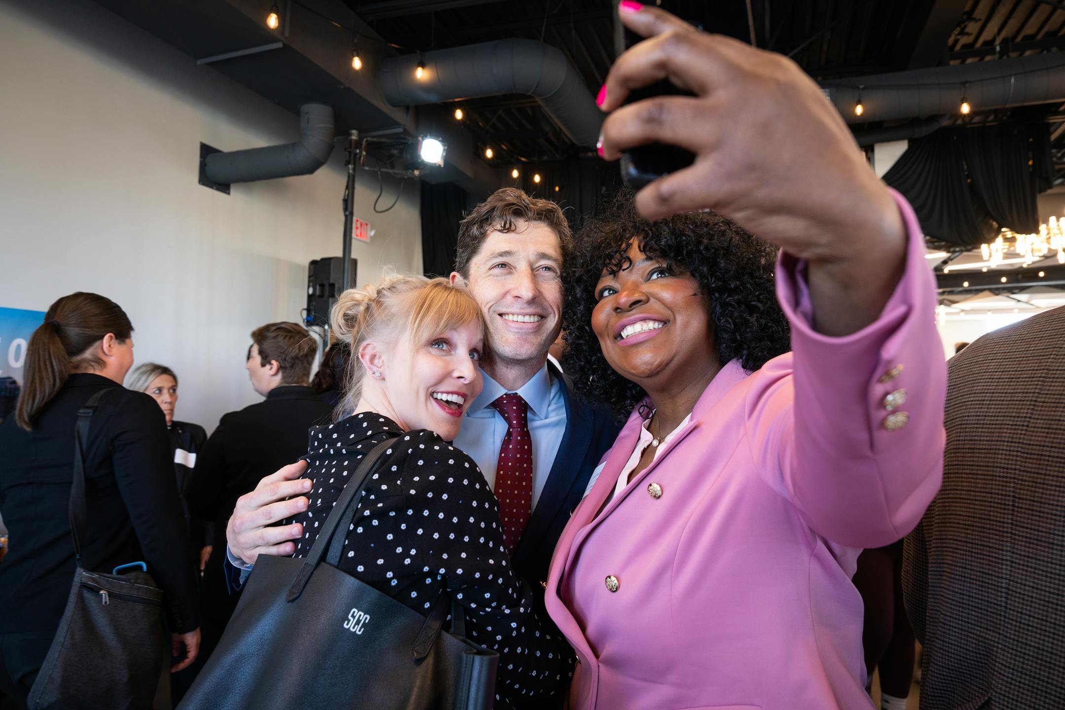 Mayor Jacob Frey, center, with his wife Sarah Clarke, left, pose for a selfie with City Council member LaTrisha Vetaw, right, after delivering his State of the City Address at the Abyssinia Event Center in Minneapolis, Minn. on Tuesday, May 6, 2025.