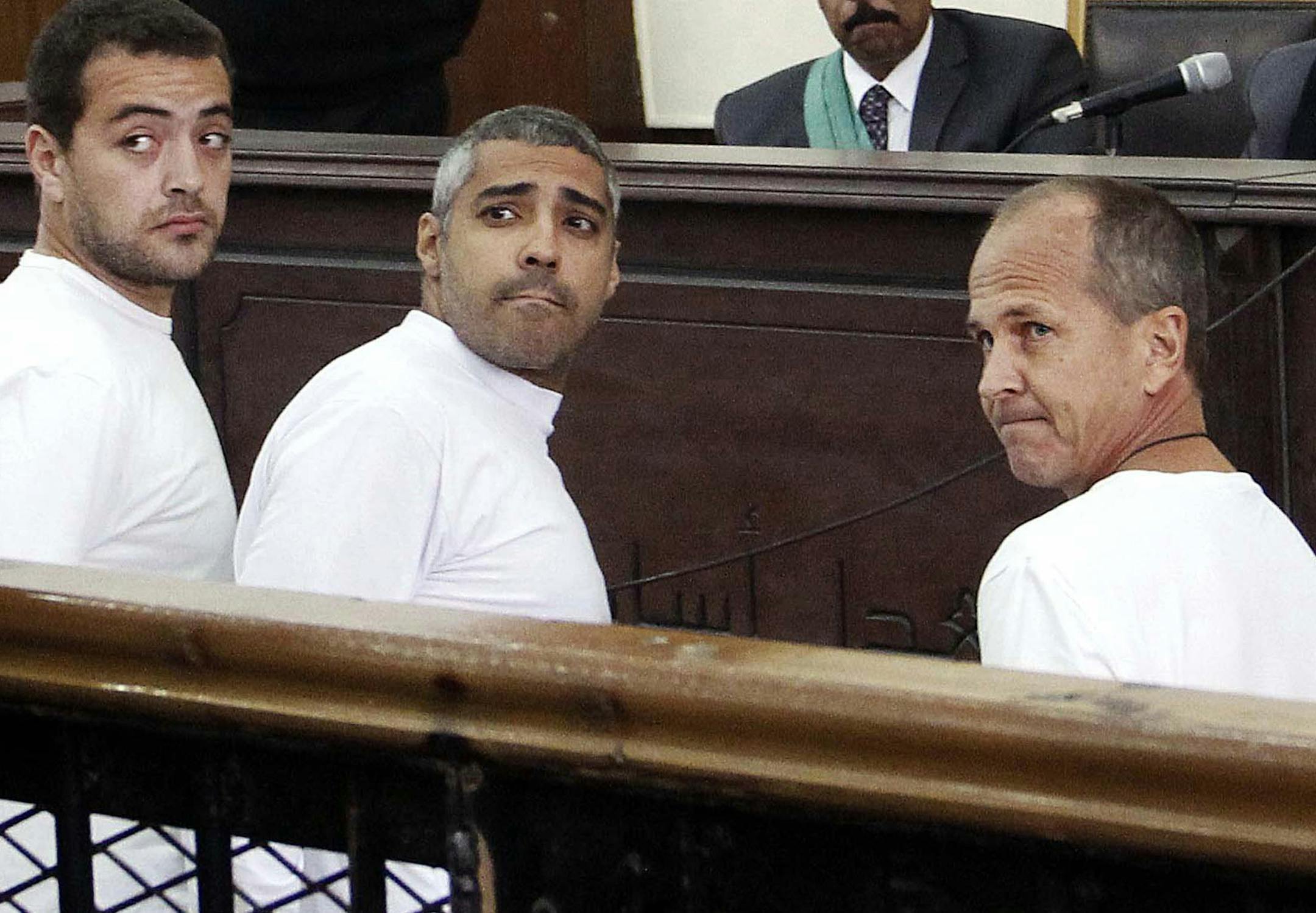 FILE - In this Monday, March 31, 2014 file photo, Al-Jazeera English producer Baher Mohamed, left, Canadian-Egyptian acting Cairo bureau chief Mohammed Fahmy, center, and correspondent Peter Greste, right, appear in court along with several other defendants during their trial on terror charges, in Cairo, Egypt. An Egyptian court on Monday, June 23, 2014, convicted three Al-Jazeera journalists and sentenced them to seven years in prison on terrorism-related charges after a trial dismissed by righ