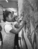 Star Tribune fileHale School had one black family before desegregation in 1971 paired it with heavily black Field School. Hale pupils Ann Mingo, 7, left, and Meg Lawson, 6, arranged a bulletin board in December 1971.