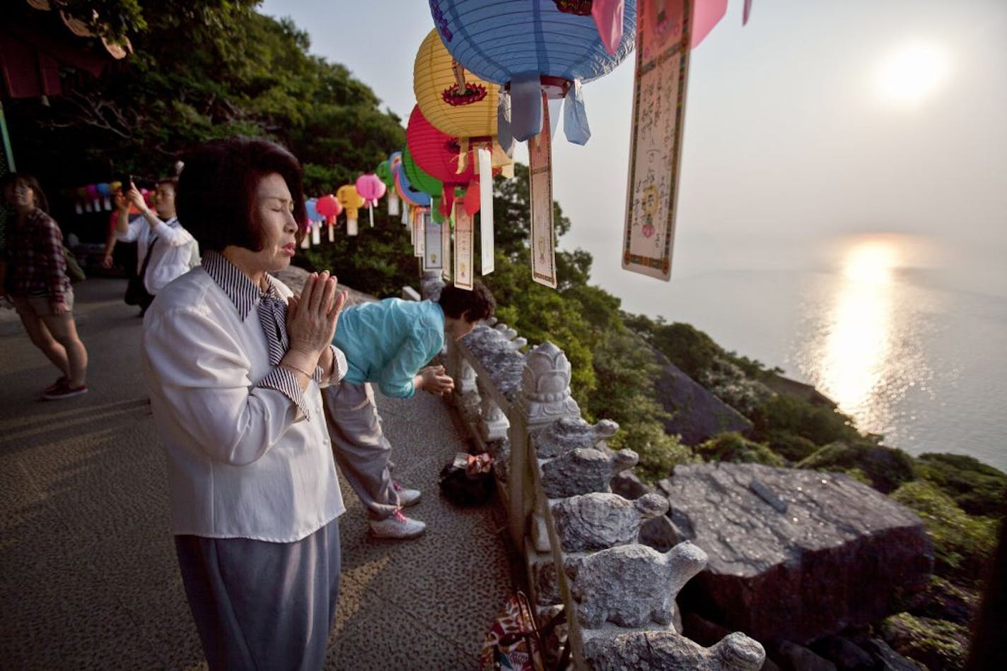 Some visitors prayed at sunrise at the Hyangiram, a Buddhist hermitage on Dolsan Island, off Yeosu, South Korea. The island is one of few attractions around Yeosu not built for the World Expo 2012, which is expected to draw 10 million visitors by the time it closes Aug. 12.