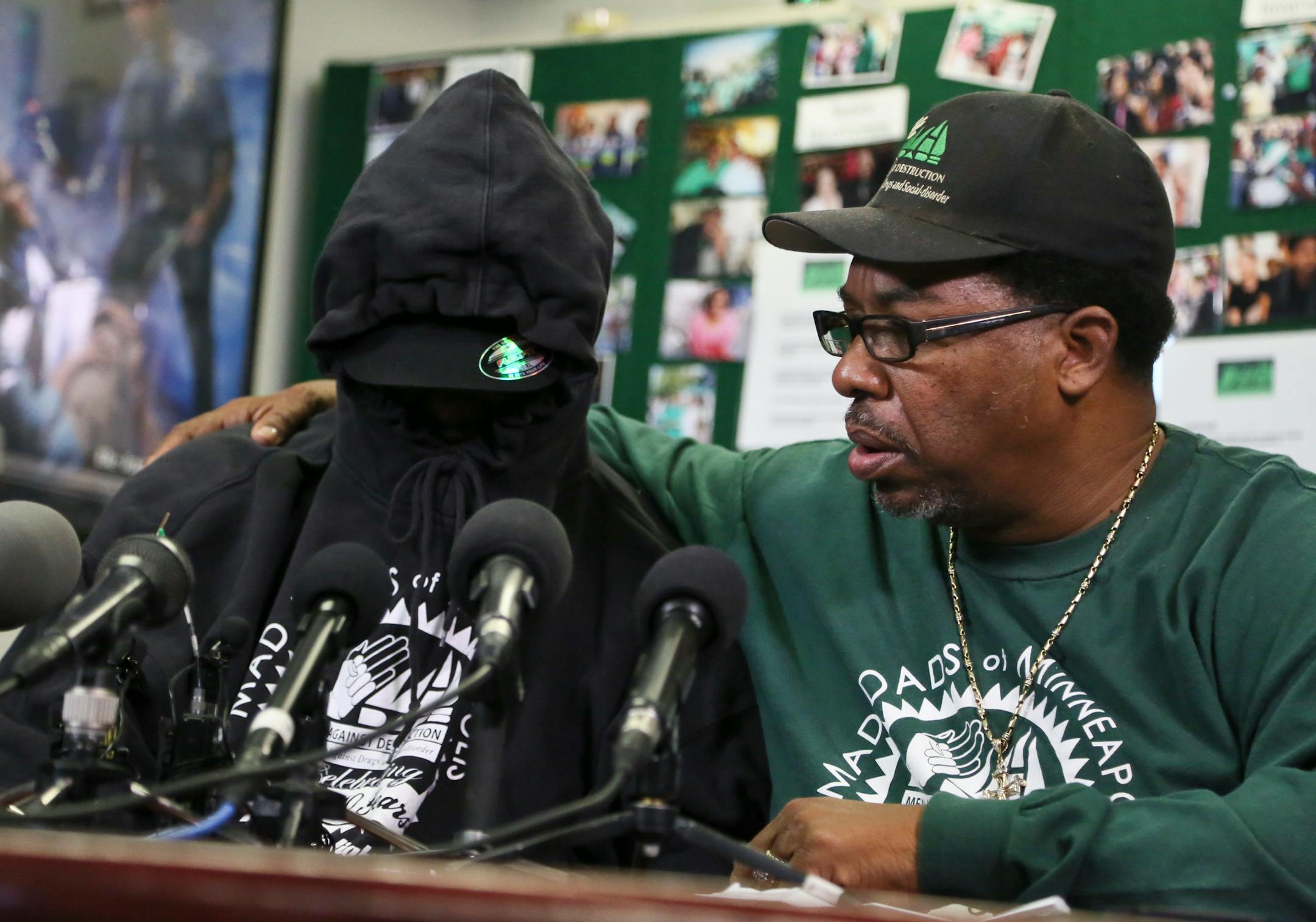 The father of the 9-year-old plane stowaway, his face covered by a hoodie and hat to ensure anonymity, talked to the media while V.J. Smith of MADDADS comforted him on Wednesday, Oct. 9, 2013.