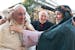 In this photo provided by the Vatican paper L'Osservatore Romano Tuesday, Jan. 7, 2014, Pope Francis is placed a lamb around his neck as he visits a l