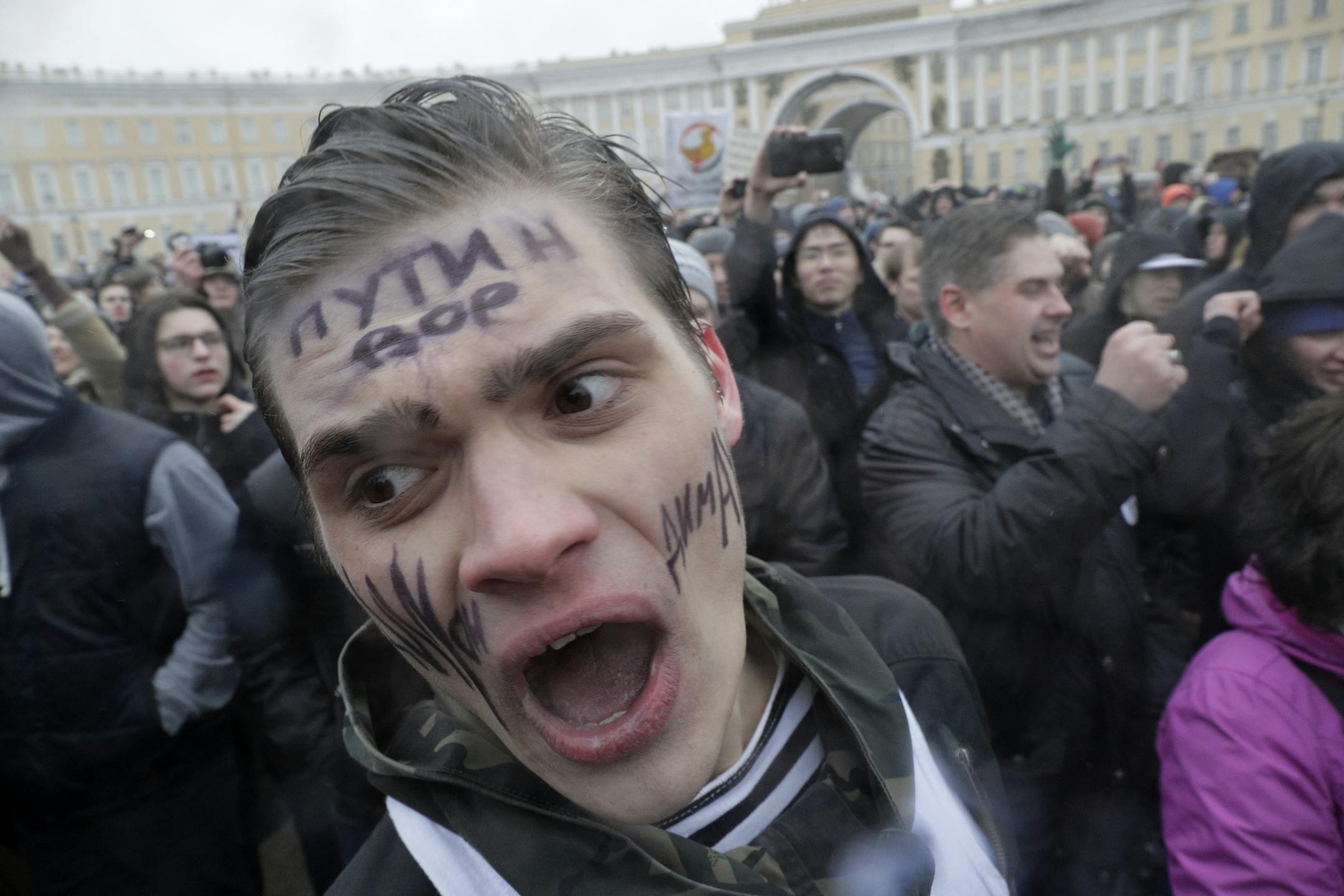 Protesters shout slogans at Dvortsovaya (Palace) Square in St.Petersburg, Russia, Sunday, March 26, 2017. Thousands of people crowded in St.Petersburg on Sunday for an unsanctioned protest against the Russian government, the biggest gathering in a wave of nationwide protests that were the most extensive show of defiance in years. The writing on the face reads 'Putin is a thief'. (AP Photo/Dmitri Lovetsky)