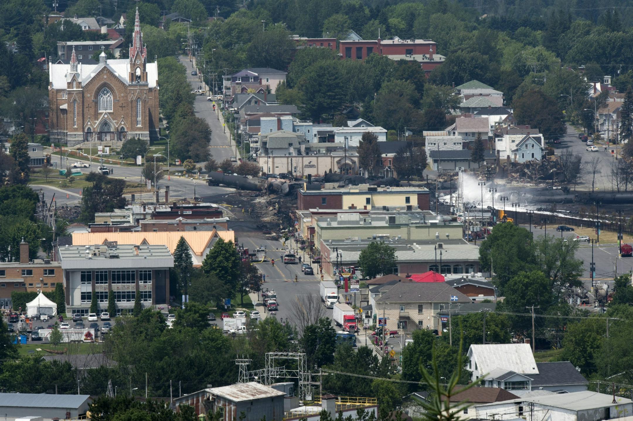 Burnt out tanker cars and the smouldering remains of businesses in downtown of Lac Megantic, Quebec is seen Sunday, July 7, 2013. A runaway train Saturday derailed, igniting explosions and fires that destroyed the downtown district.