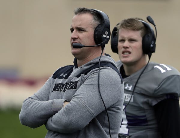 Northwestern head coach Pat Fitzgerald, left, watches his team during the second half of an NCAA college football game against Wisconsin in Evanston, 
