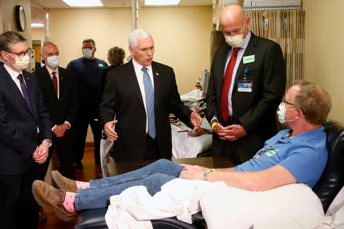 Vice President Mike Pence, center, visited a Mayo employee who has recovered from COVID-19 and was donating plasma during a tour of the Mayo Clinic Tuesday, April 28, 2020, in Rochester, Minn. Pence chose not to wear a face mask while touring the Mayo Clinic in Minnesota.