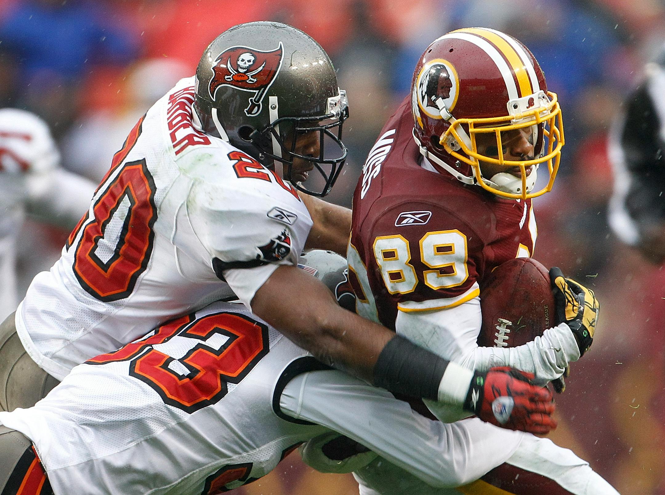 Tampa Bay cornerback Ronde Barber (20), helping to bring down Santana Moss on Sunday, is still standing in his 14th NFL season — unlike many of his teammates.