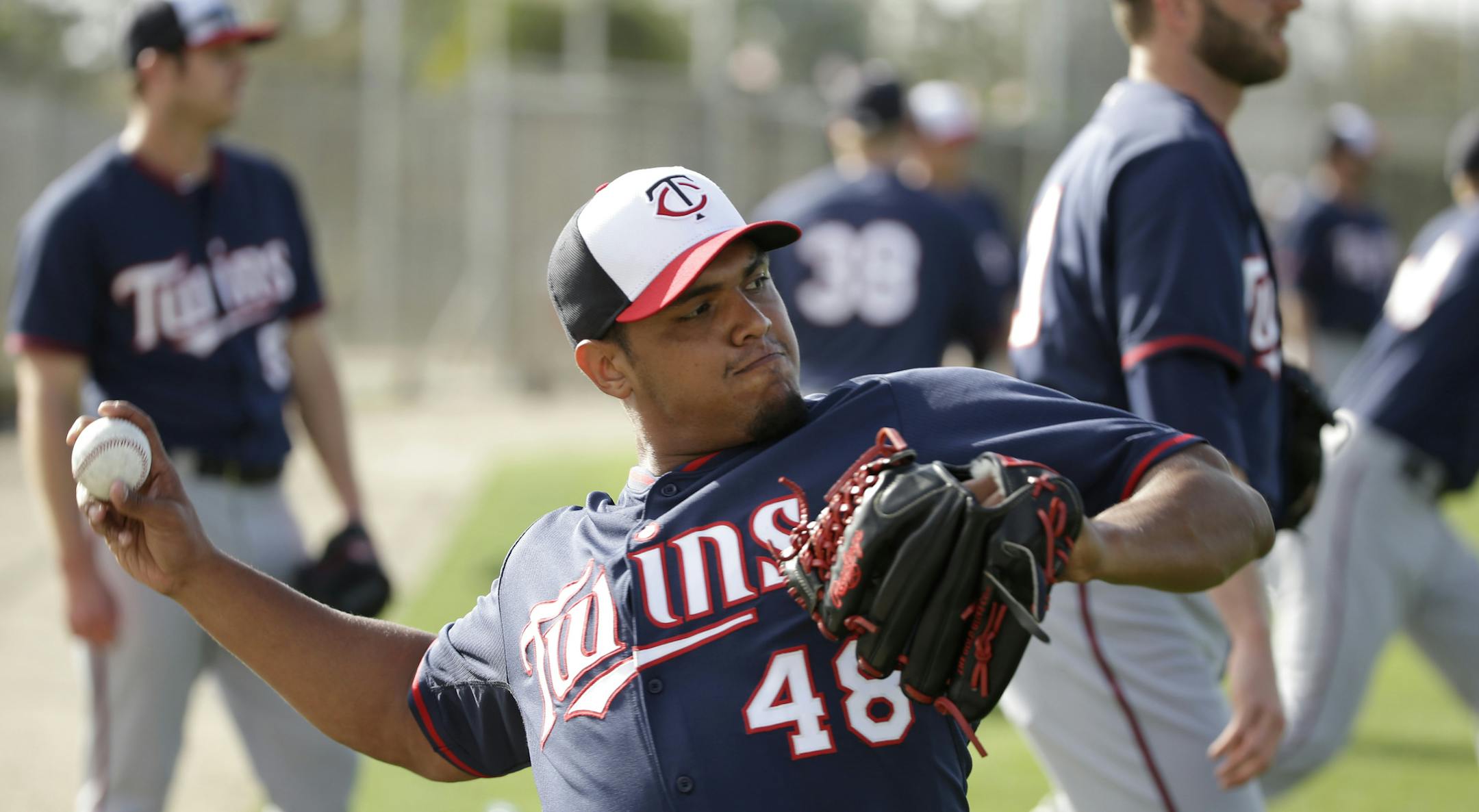 Minnesota Twins pitcher Lester Oliveros winds up for a throw during spring training baseball practice Friday, Feb. 21, 2014, in Fort Myers, Fla. (AP Photo/Steven Senne)