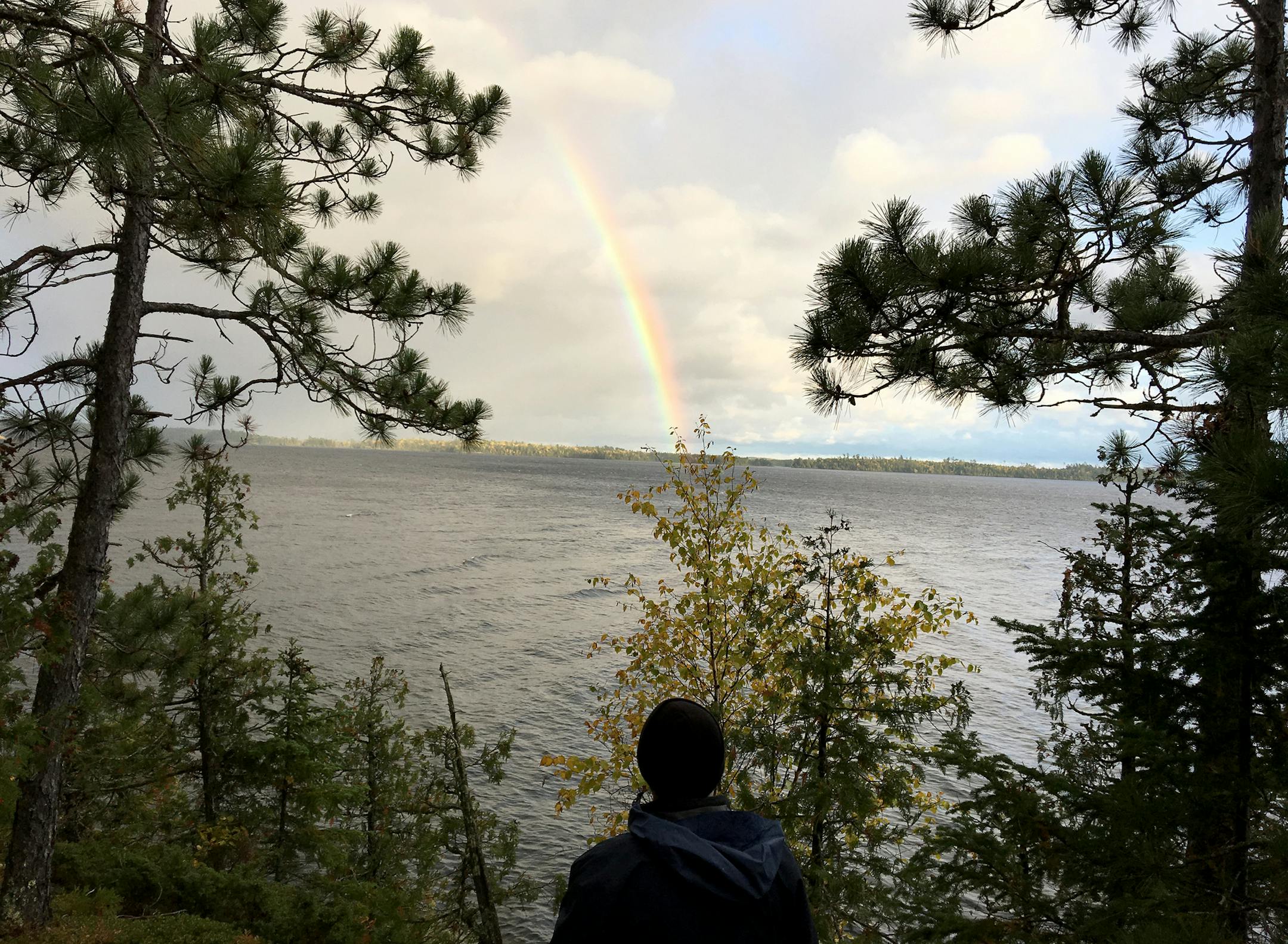 Soon after we took off in the tow boat up the Seagull River to Lake Saganaga to be dropped off on Hook Island on October 8, 2019, my brother Curtis and I realized there was no way we were going to be able to leave that day for our canoe trip. The winds from the northwest were creating 2' waves into which would have been heading. After setting up camp and getting a fire started during a rain/sleet shower, we were treated with a spectacular rainbow. The photo of my brother admiring this was taken
