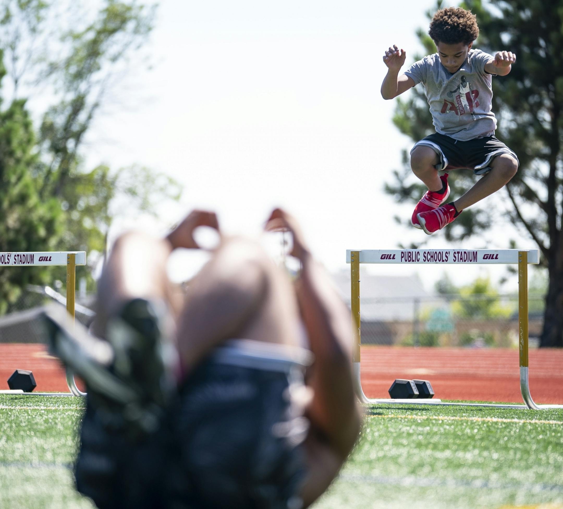 Adili Elfundi jumped over a hurdle while Jayden Hester did sit-ups did during the Denfeld football team's workout on Tuesday morning.