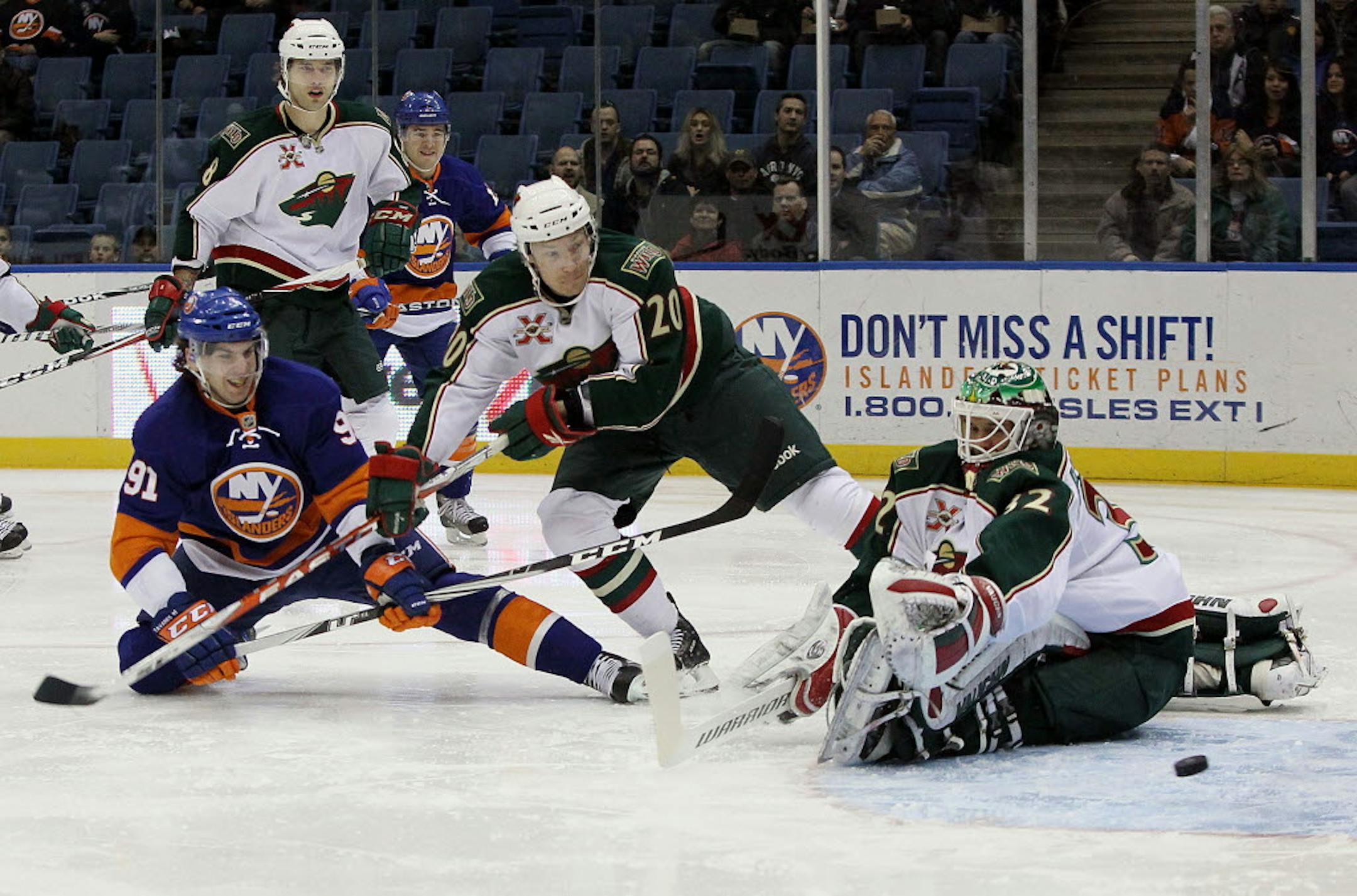 John Tavares (91) of the New York Islanders just missed a first-period goal against Antti Miettinen (20) and Niklas Backstrom, right, of the Wild.