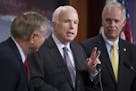 Sen. John McCain, center, appeared with Sen. Ron Johnson, right, at a press conference about the health insurance legislation on July 27.