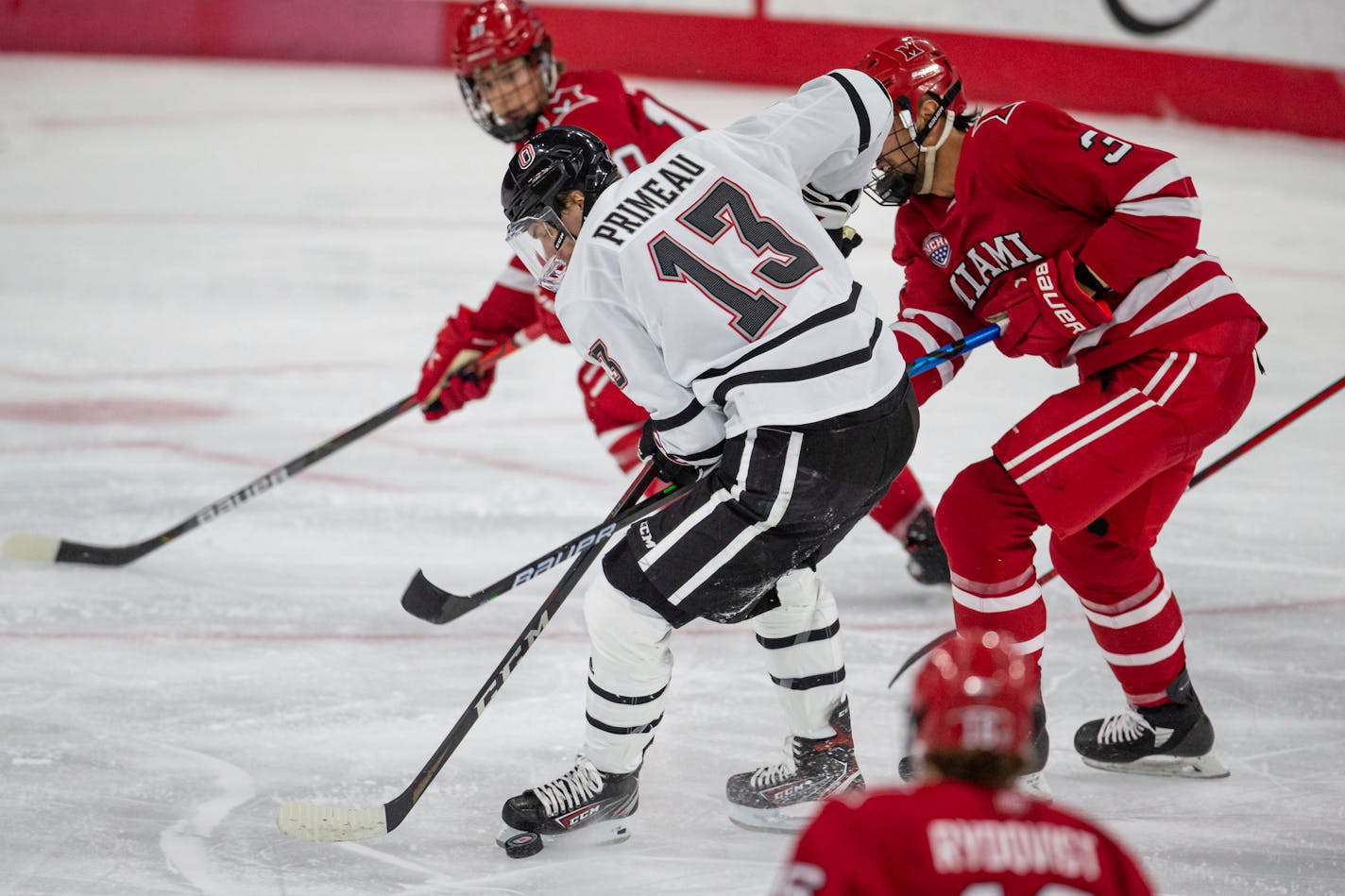 Nebraska-Omaha forward Chayse Primeau (13) battles Miami defenseman Bray Crowder (3) for the puck during an NCAA hockey game on Saturday, Dec. 5, 2020, in Omaha, Neb. (AP Photo/John Peterson)