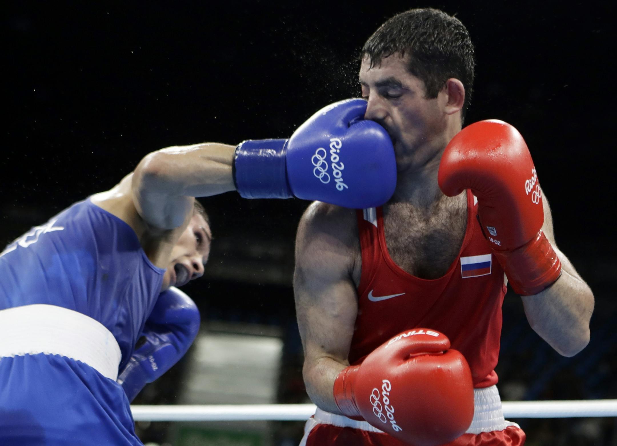 Colombia's Ceiber David Avila, left, lands a punch on Russia's Misha Aloian during a men's flyweight 52-kg quarterfinals boxing match at the 2016 Summer Olympics in Rio de Janeiro, Brazil, Wednesday, Aug. 17, 2016.