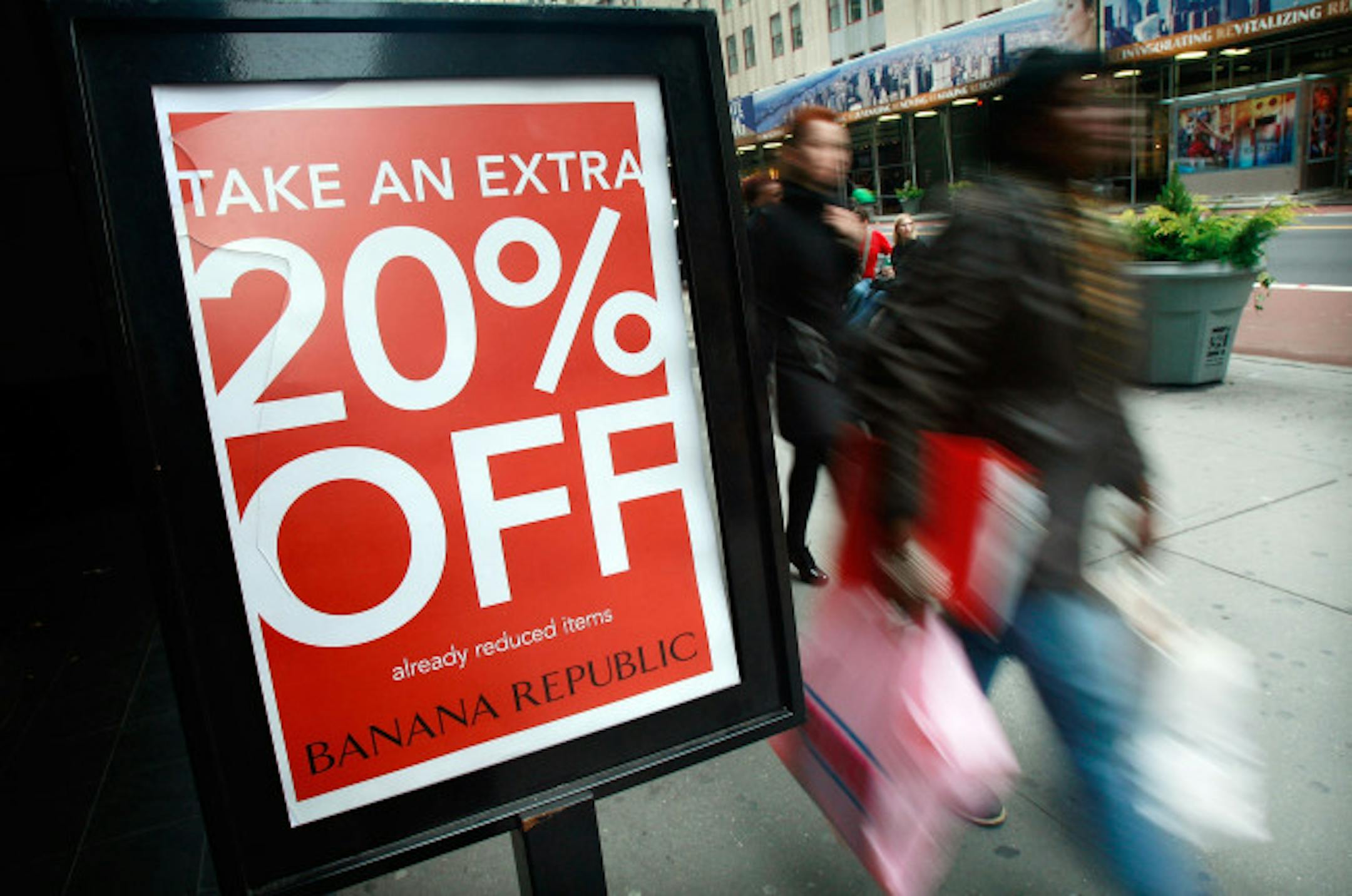 NEW YORK - NOVEMBER 14: A shopper carries bags past a "20% off" sign outside a Banana Republic November 14, 2008 in New York City. The Commerce Department reported today that retail sales fell by a record 2.8 percent last month in another worrisome sign for the economy.