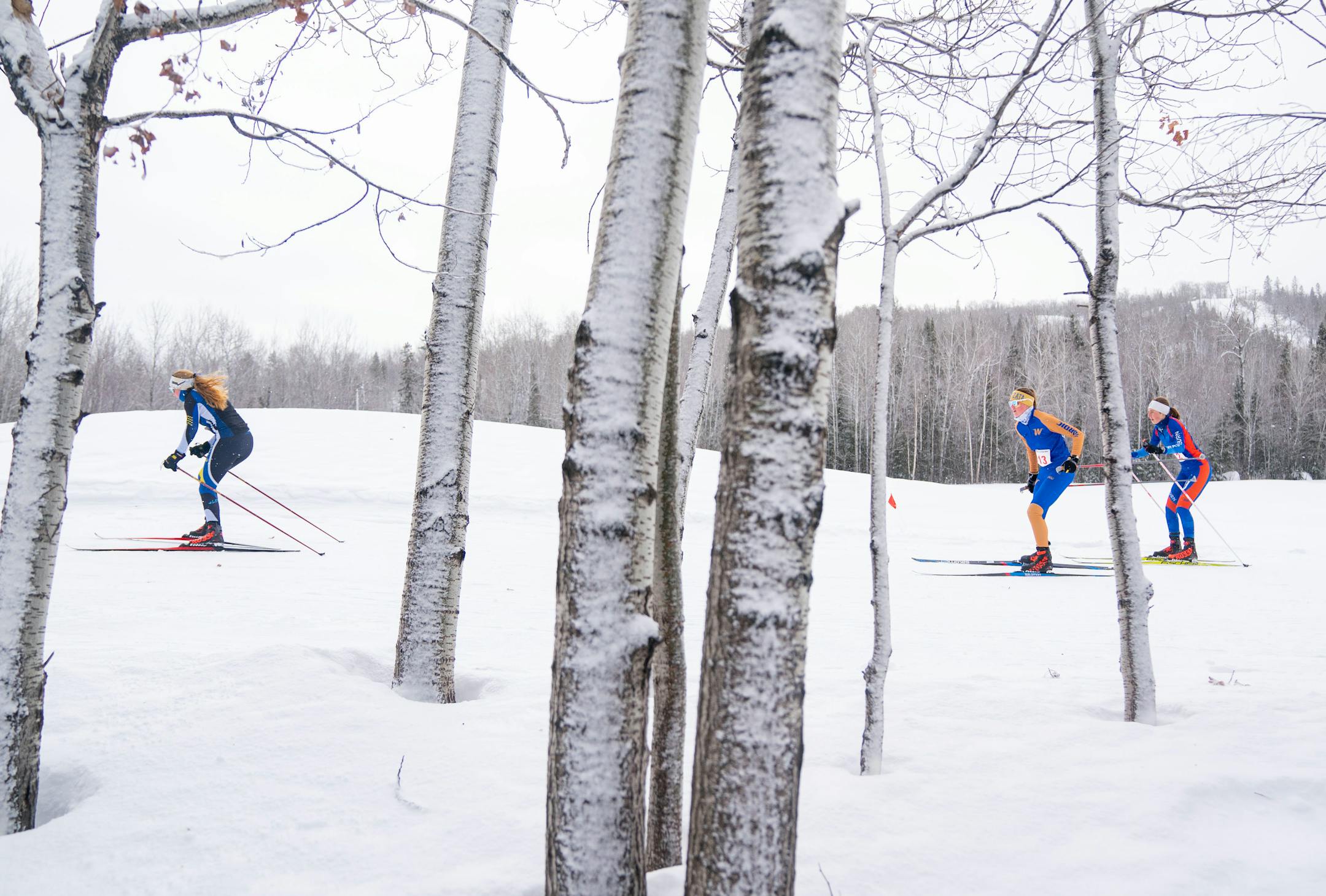 Sartell/St. Cloud Cathedral nordic skier Lillian Jamison (16), Wayzata nordic skier Erin McMaster (13), Washburn nordic skier Poppy Lowenthal Walsh (12), left to right, compete in the girl's team sprint qualification race during the MSHSL Boys and Girls Nordic Ski Racing Meet.