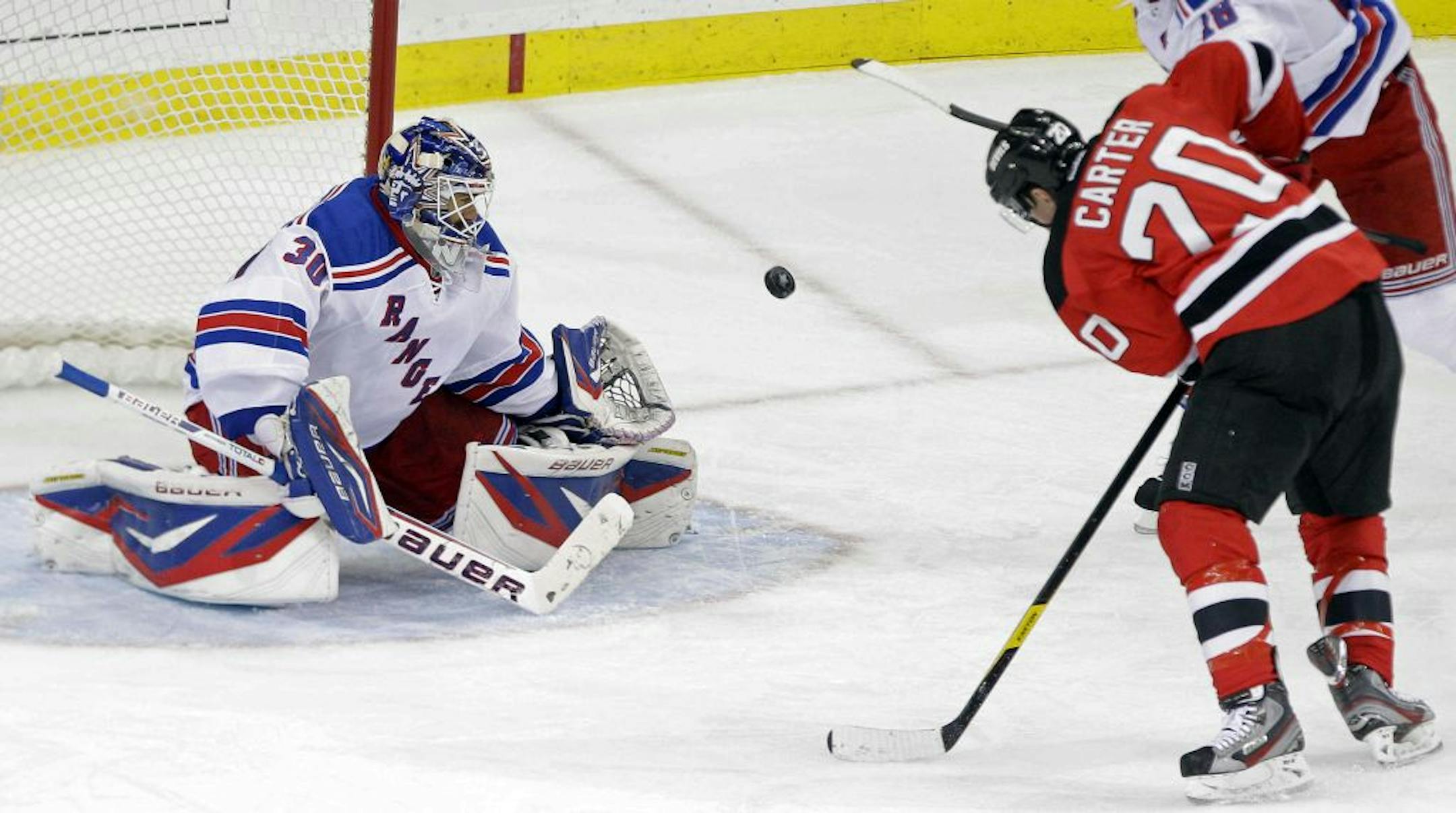 Rangers goalie Henrik Lundqvist (30) stopped a shot by the Devils' Ryan Carter (20) during the third period of Game 3 of a Stanley Cup Eastern Conference final playoff series on May 19, 2012.