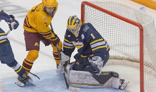 Gophers sophomore Aaron Huglen took a shot against Michigan goalie Erik Portillo during the Wolverines’ 5-4 overtime victory in Minneapolis on Jan. 