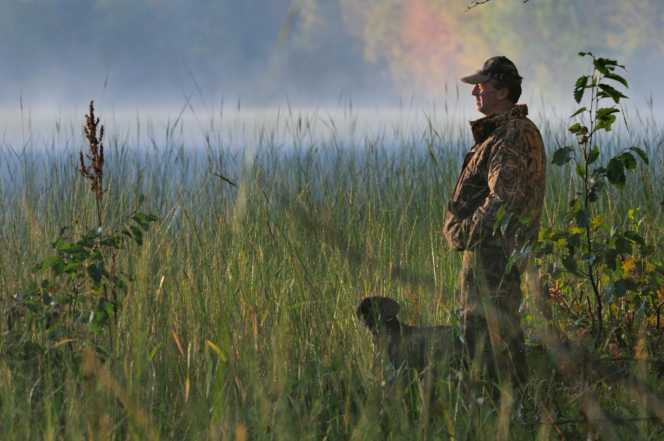 A duck hunter and his dog watch for game along the Mississippi River north of Brainerd. Undeveloped shoreline such as this provides ideal habitat for not just wildlife, but fish also.