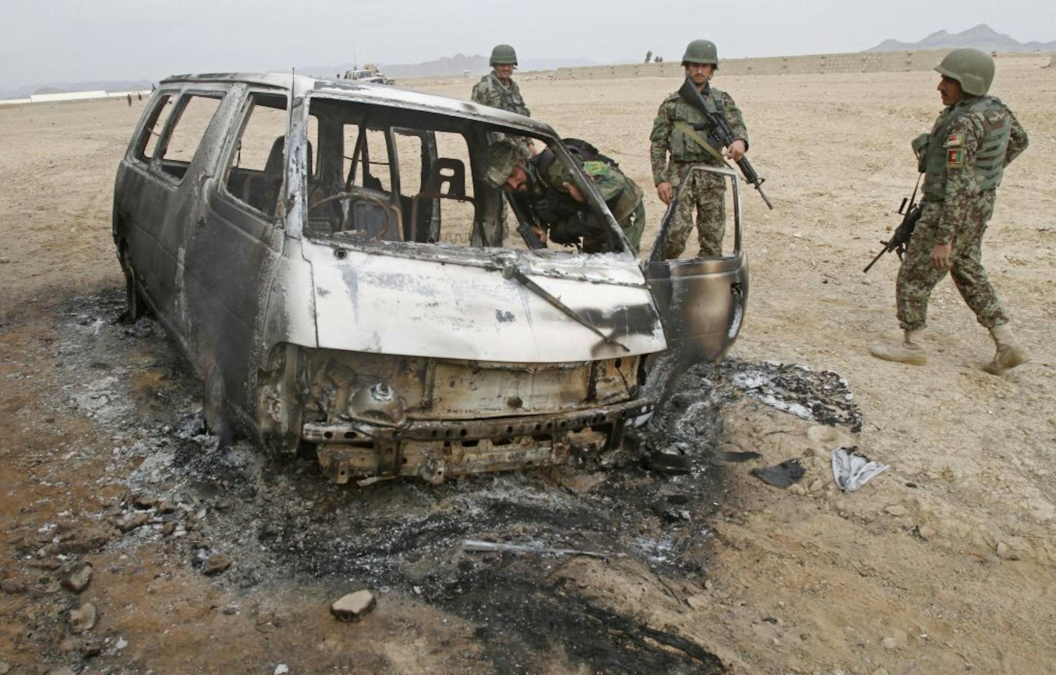 Afghan National Army soldiers investigate the site of a deadly assault by suicide bombers and gunmen against a NATO base in Zhari west of Kandahar city, Afghanistan, Monday, Jan. 20, 2014. Five National Guard members from Minnesota were wounded in the attack.