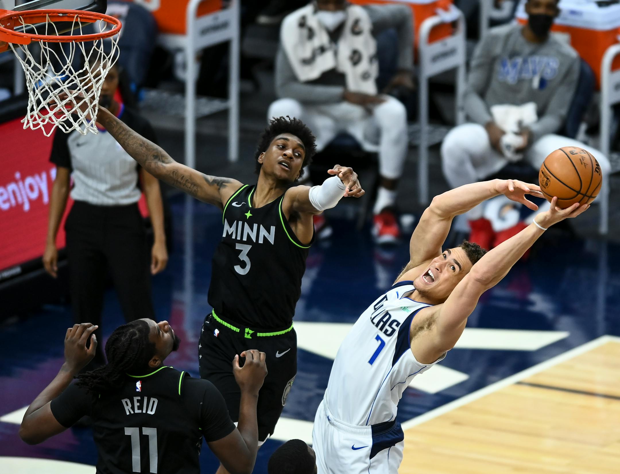 Dallas Mavericks center Dwight Powell (7) was unable to come up with an offensive rebound as he was defended by Minnesota Timberwolves forward Jaden McDaniels (3) and center Naz Reid (11).